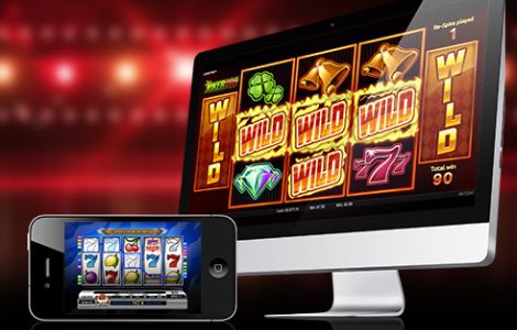 En datorskärm och en mobiltelefon som det spelas casinospel på.